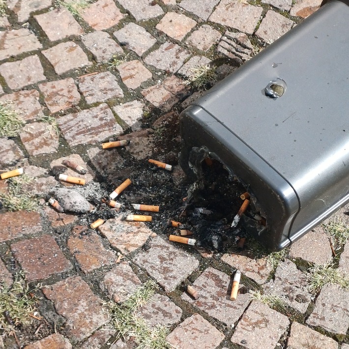Der angebrannte Mülleimer mit den Zigarettenresten
